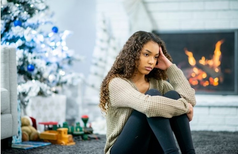 Woman holding her chest to her knees. Lonely for the holidays.
